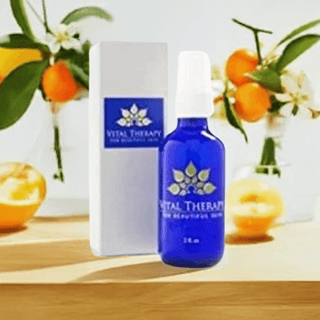 Vitamin C Caffeine Daytime Serum bottle with packaging, surrounded by fresh oranges, USA-made skincare product.
