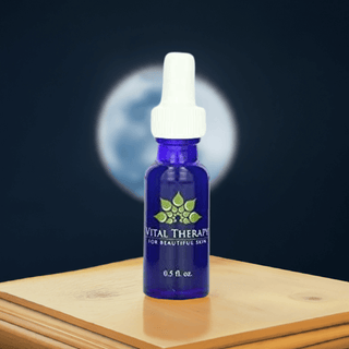 Blue bottle of Vitamin A Complex Nighttime Serum by Vital Therapy for skincare with moonlit backdrop.