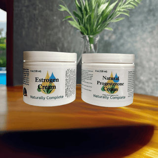 Estrogen and Progesterone Cream Jars for Menopause Relief, Soy-Free, Non-GMO, Plant-Based, on a Table with Green Plant Background.