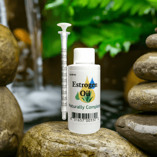 Estrogen Oil 2 oz bottle with syringe, plant-based, soy-free, non-GMO, for menopausal relief, set on natural stones and greenery.
